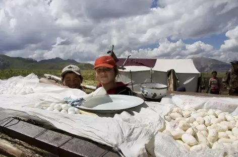 Jeunes nomades posant devant les qurut (fromages) - Kirghizie