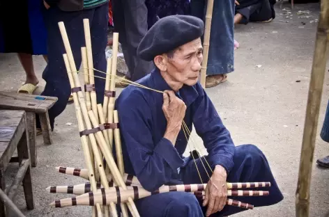 Un Hmong Noir vend des instruments de musique sur le marché de Dong Van