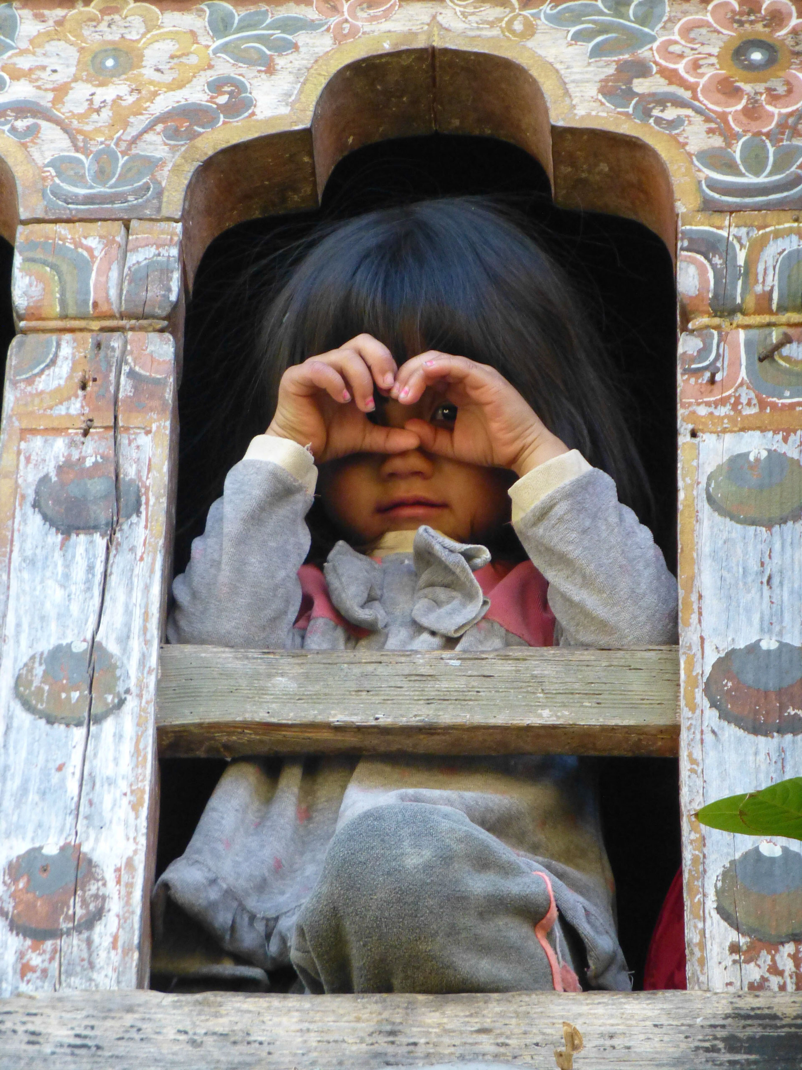 Les enfants, à la fois curieux et timides, observent ces drôles de danses depuis les étroites fenêtres des maisons traditionnelles - Triptyque himalayen
