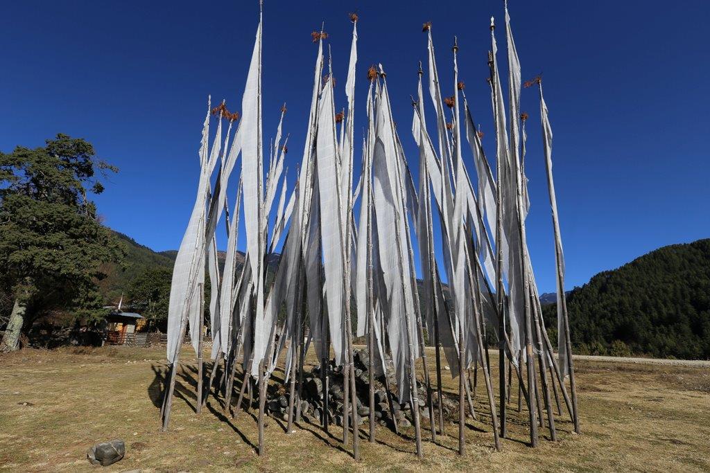 Tas de pierres rondes entourées de bannières de la victoire, c'est l'ancêtre animiste du Chorten