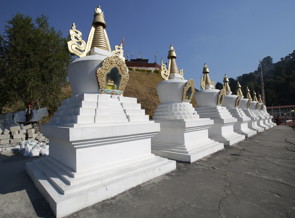 Huit chortens blancs marquent l'entrée du monastère du Garab Rinpoche
