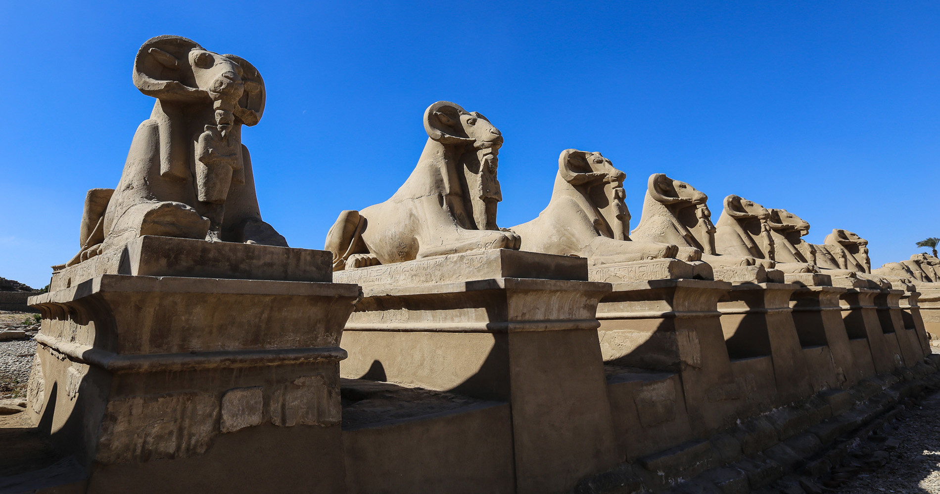 Une allée de Sphinx à têtes de béliers mène à l’entrée principale