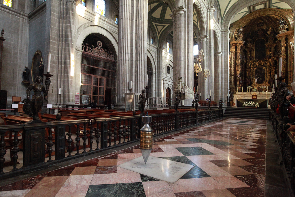 Au centre de la nef, un fil à plomb qui mesure l’inclinaison de l’ensemble ! Au fond, le retable des rois constitue de chef d’œuvre absolu de l’art churrigueresque mexicain - Centre historique de Mexico