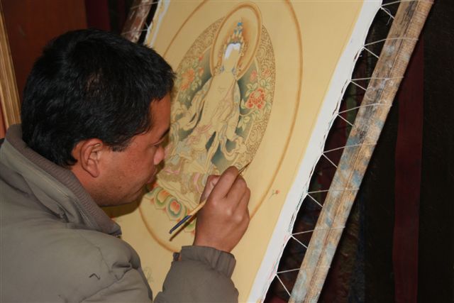 Artiste en cours de confection d'un mandala